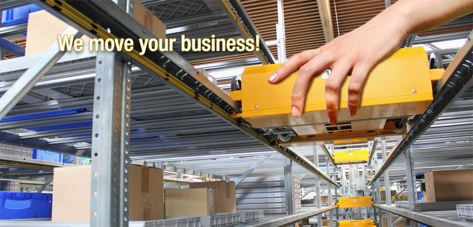 A human hand is moving a shuttle system in a warehouse.
